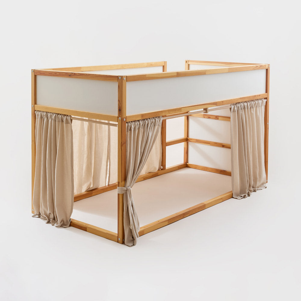 IKEA Kura Bett mit Vorhängen aus Musselinstoff in Beige.