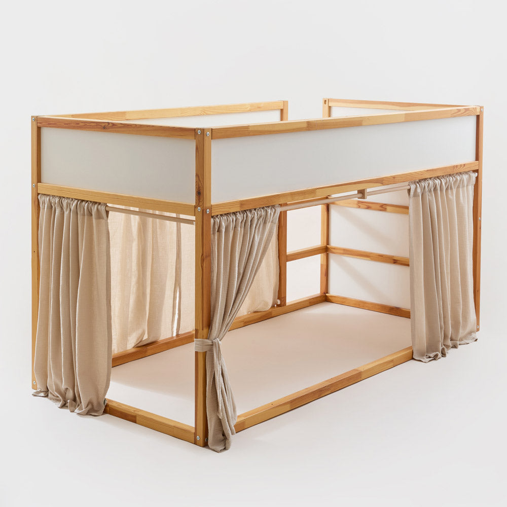 IKEA Kura Bett mit Vorhängen aus Musselinstoff in Beige.