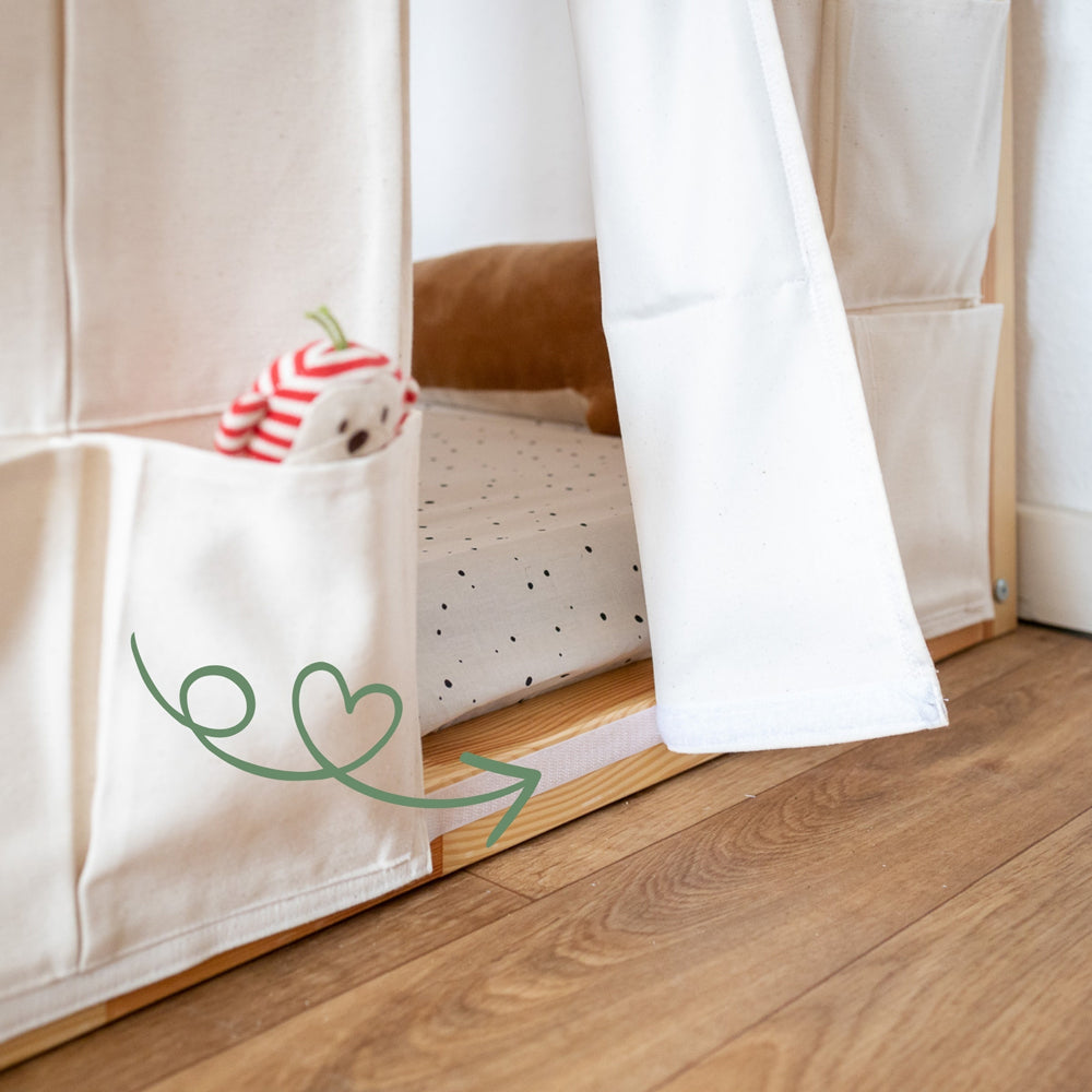 Detailaufnahme der Befestigung der textilen Kura Aufbewahrung durch am Bett angebrachte Klettbänder.