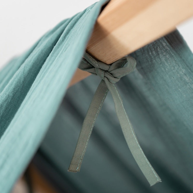 Detailansicht IKEA Kura Baldachin aus grünem Musselinstoff.