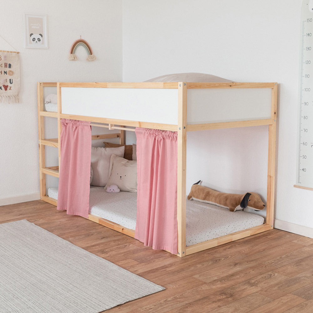Ikea Hochbett mit einem rosa farbenden Vorhang an der Leiterseite