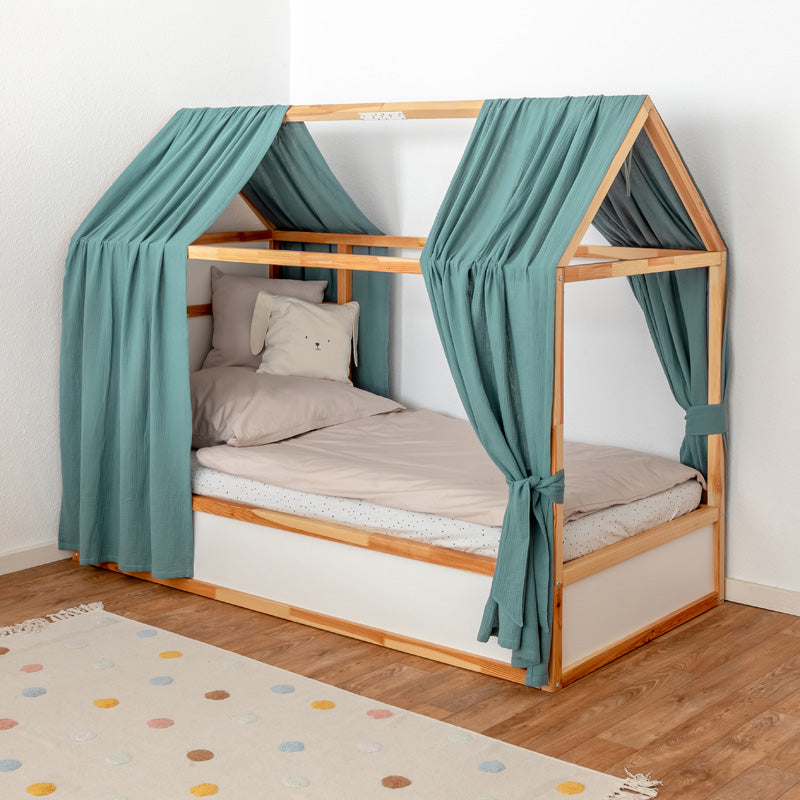 IKEA Kura Bett mit Dach und 2 Baldachinen aus grünem Musselinstoff.