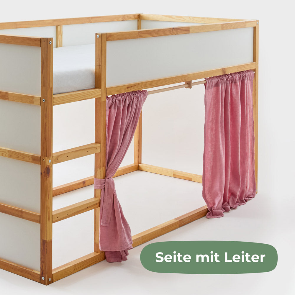Kura Hochbett mit Vorhängen aus rosa Musselinstoff.