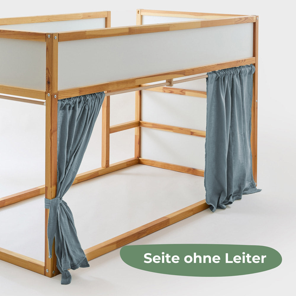 Kura Bett von der Seite ohne Leiter mit passenden Vorhängen aus blauem Musselin.