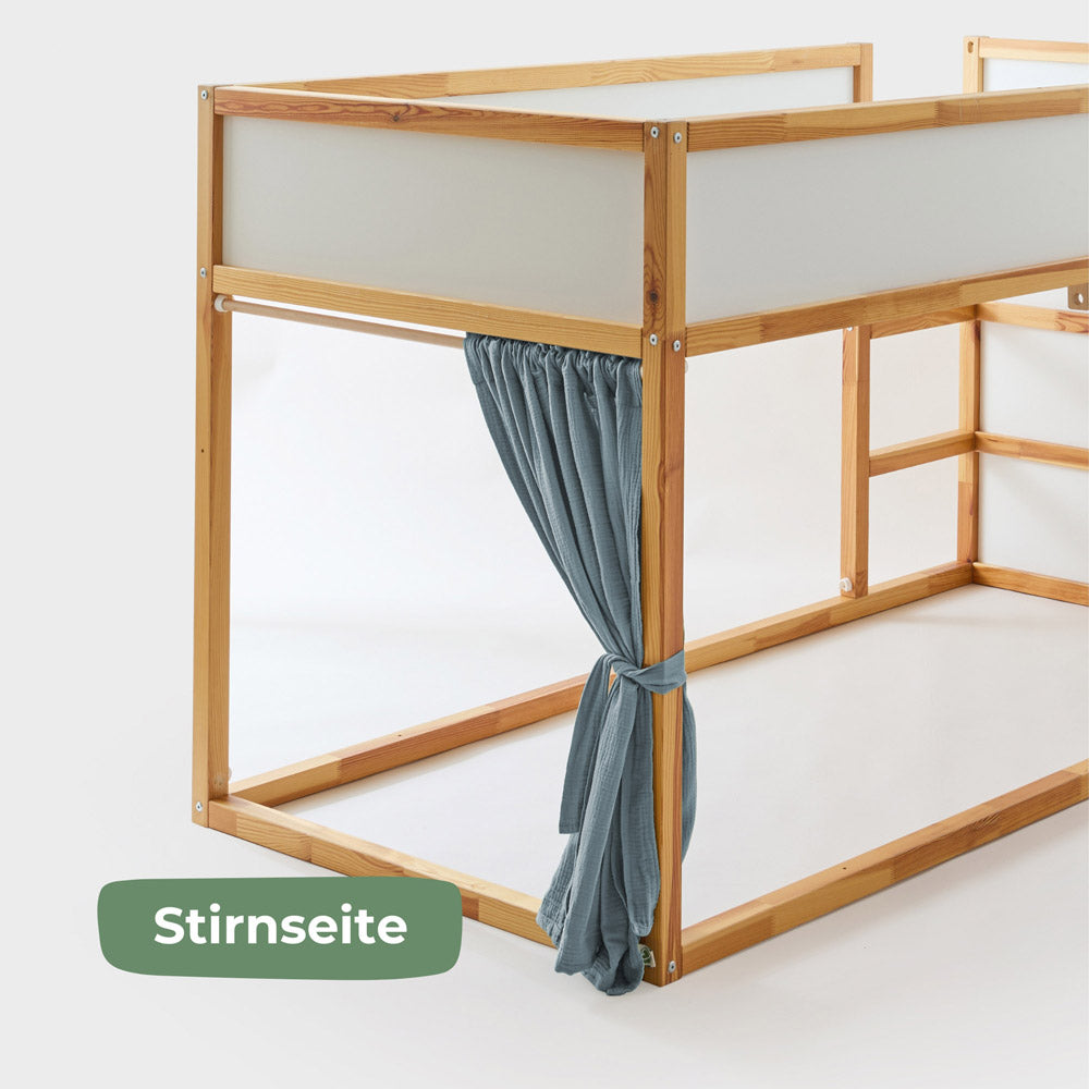 Stirnseite des Kura Bett mit passendem Vorhang aus blauem Musselin.