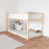 Seitenansicht eines Kura Betts von Ikea als Hochbett mit Leiter und angebrachter Stange für Vorhänge