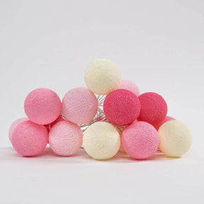Pink farbende Lichterkette bestehend aus auf dem Haufen liegender Cotton Ball Kugeln